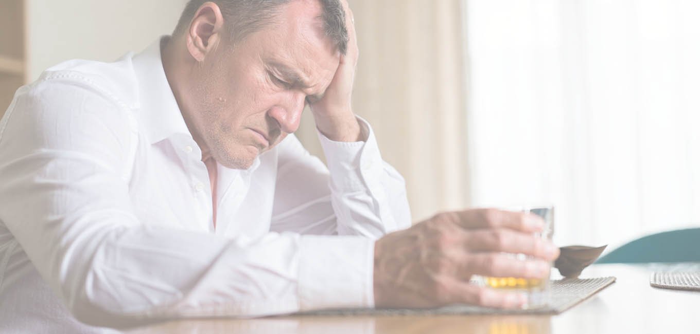 Мужчина облокотившись на руку сидит за столом